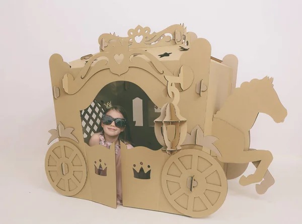 Linda niña caucásica en vestido rosa pastel princesa preparándose para la fiesta de cumpleaños y posando en carruaje de cuento de hadas . —  Fotos de Stock