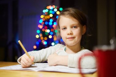 Masada ilham küçük kız boya kalemi ile çizmek ya da ev iş.
