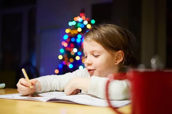 Ispirato bambina al tavolo disegnare con pastelli o fare il lavoro a casa — Foto Stock