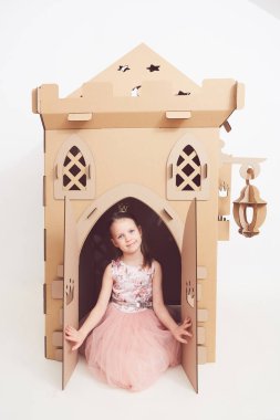 Küçük Prenses tacı karton onu kale ile oynamak. Çocuğun mutluluğun gerçek duygu.