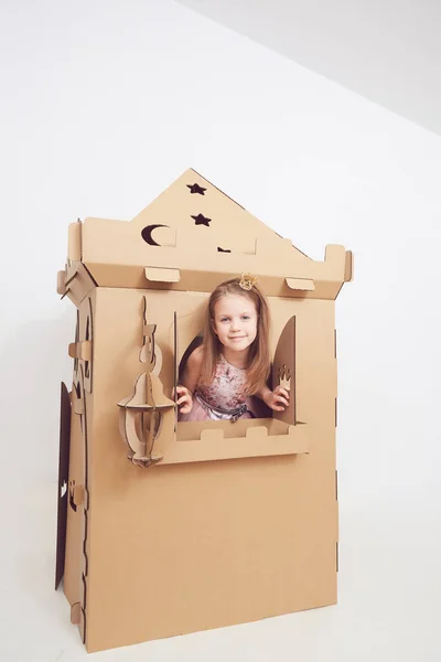 Little princess in crown play with her cardboard castle. True emotion of happiness of the child. — Stock Photo, Image