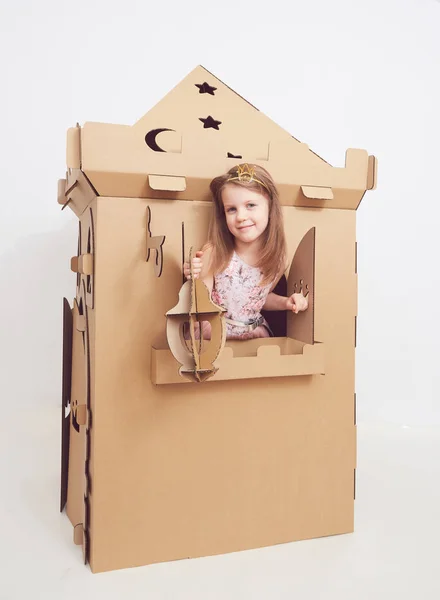 Little princess in crown play with her cardboard castle. True emotion of happiness of the child. — Stock Photo, Image