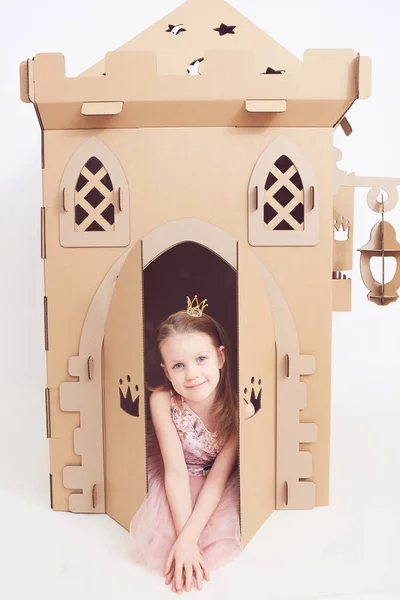 Pequeña princesa en juego de corona con su castillo de cartón. La emoción verdadera de la felicidad del niño . —  Fotos de Stock