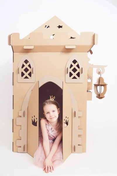 In crown prinsesje spelen met haar kartonnen kasteel. Echte emotie van geluk van het kind. — Stockfoto