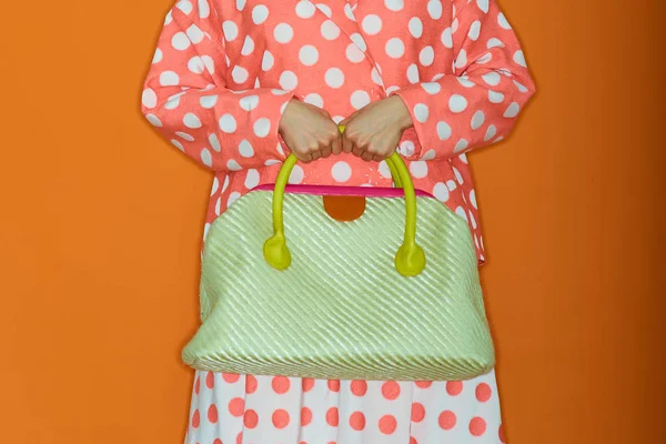 De cerca la foto del bolso a la moda violeta con la baratija de piel en las manos de la mujer a la moda posando en la calle con los árboles florecientes primaverales. Elementos de moda . — Foto de Stock