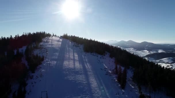 Luchtfoto landschap de helling van de sneeuw met skilift in winter skigebied. Winter activiteit op uitzicht op luxe ski resort drone. — Stockvideo