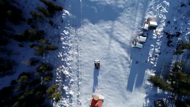 Vackra vinter flyg flyg av drönare över bergen och skidorten. Snowcat började sitt skift, förbereda backarna för nästa dag. 4k. — Stockvideo