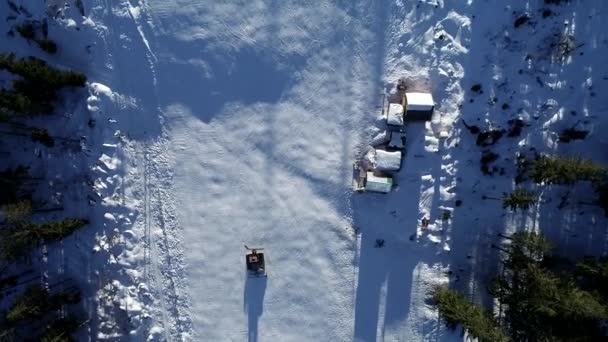 겨울에 스키 리조트 슬로프에 snowcat 또는 눈 groomer의 보기 공중 하향식 — 비디오