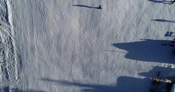 Une belle prise de vue aérienne des skieurs dans une station de ski de montagne enneigée . — Video