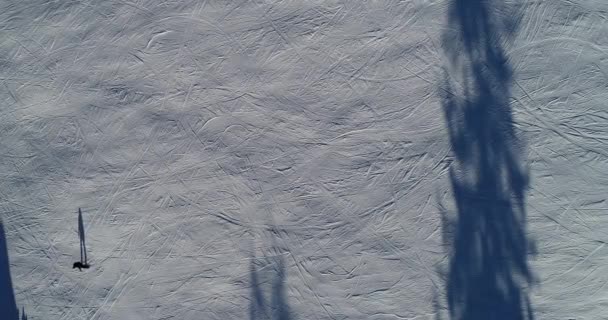 Eine schöne Luftaufnahme von Menschen beim Skifahren in einem verschneiten Skigebiet in den Bergen. — Stockvideo