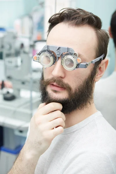 Jonge man met trial frames in oogarts kliniek — Stockfoto