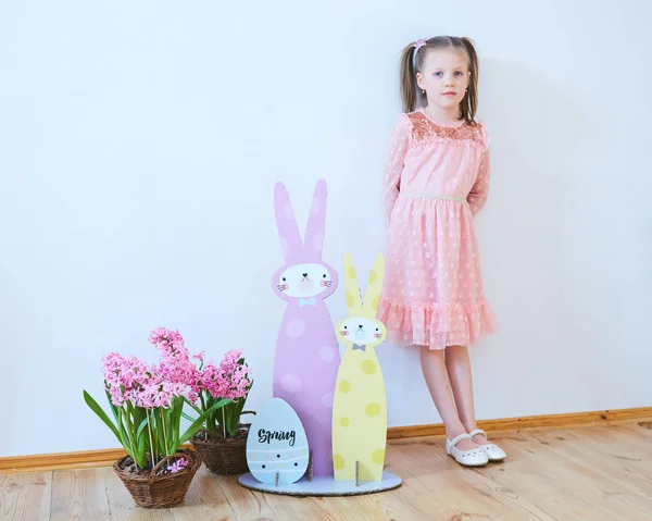 Påsk 2019 vacker liten flicka i en klänning med påskpynt. Stora påskharar. En massa olika färgglada påsk inredning. Mångfärgade inredning — Stockfoto