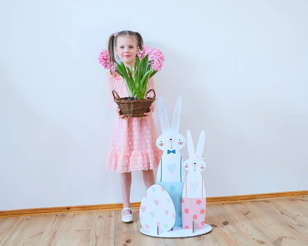 Easter 2019 Beautiful little girl in a dress with Easter decorations. Big Easter eggs and bunnies, colorful place. A lot of different colorful Easter eggs. Multicolored decor — Stock Photo, Image