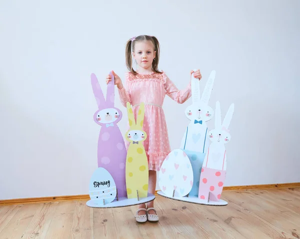 Wielkanoc 2019 piękna dziewczynka w sukience z ozdoby wielkanocne. Duże króliczki. Sporo różnych kolorowych wnętrzach Wielkanoc. Wielobarwny wystrój — Zdjęcie stockowe