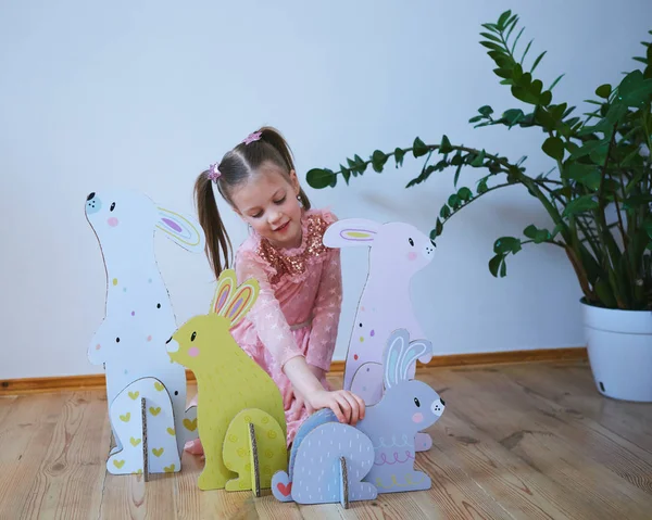 Easter 2019 Beautiful little girl in a dress with Easter decorations. Big Easter bunnies. A lot of different colorful Easter decor. Multicolored decor — Stock Photo, Image