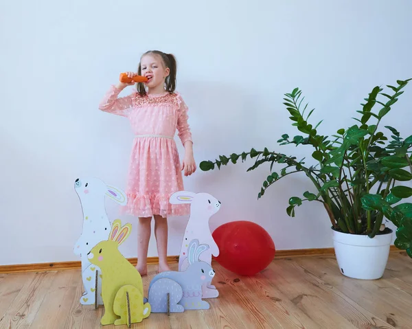 Easter 2019 Beautiful little girl in a dress with Easter decorations. Big Easter bunnies. A lot of different colorful Easter decor. Multicolored decor — Stock Photo, Image