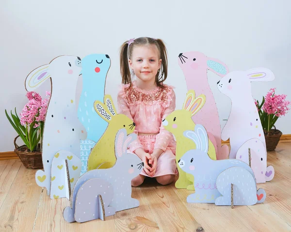 Semana Santa 2019 Hermosa niña en un vestido con decoraciones de Pascua. Grandes conejitos de Pascua. Una gran cantidad de decoración de Pascua de colores diferentes. Decoración multicolor —  Fotos de Stock