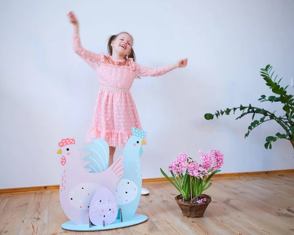 Semana Santa 2019 Hermosa niña en un vestido con decoraciones de Pascua. Grandes huevos de Pascua y conejitos, lugar colorido. Un montón de diferentes huevos de Pascua de colores. Decoración multicolor — Foto de Stock