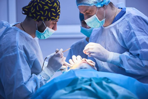 外科团队在现代手术室进行手术, 医生团队在手术中专注于病人, 医生团队在手术室手术中一起工作. — 图库照片