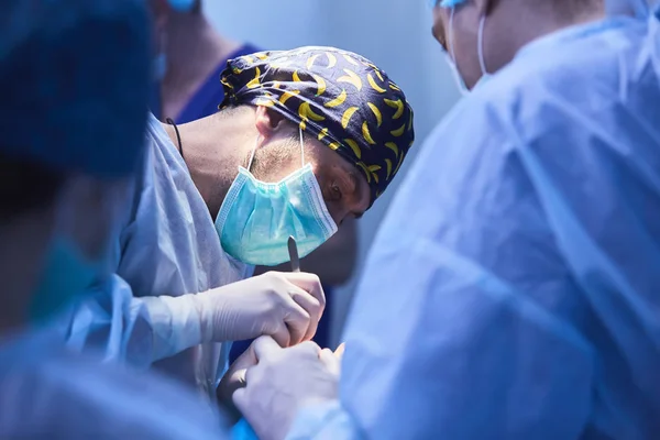 Serious surgeons during a surgery in the hospital. Cross Process — Stock Photo, Image