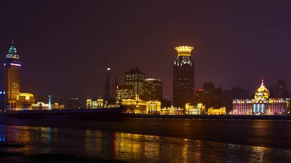 Shanghai, China - 12 de marzo de 2016: El Bund es una zona costera que corre a lo largo de la orilla occidental del río Huangpu, frente a los rascacielos de Pudong. Luces nocturnas en el Bund mirando hacia el sur en Huangpu — Foto de Stock