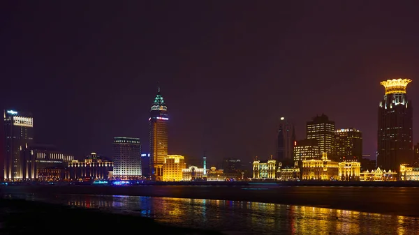 Shanghai, Cina - 12 marzo 2016: Il Bund è un'area sul lungomare che corre lungo la riva occidentale del fiume Huangpu, di fronte ai grattacieli Pudong. Luci notturne sul Bund guardando a sud a Huangpu — Foto Stock