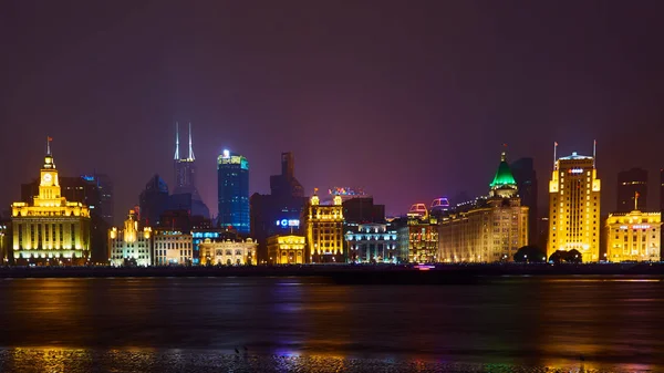 Shanghai, China - 12 de marzo de 2016: El Bund es una zona costera que corre a lo largo de la orilla occidental del río Huangpu, frente a los rascacielos de Pudong. Luces nocturnas en el Bund mirando hacia el sur en Huangpu —  Fotos de Stock