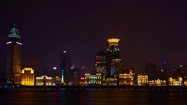 Shanghai, Cina - 12 marzo 2016: Il Bund è un'area sul lungomare che corre lungo la riva occidentale del fiume Huangpu, di fronte ai grattacieli Pudong. Luci notturne sul Bund guardando a sud a Huangpu — Foto Stock