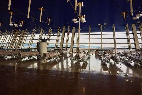 Zona de espera del aeropuerto con filas de asientos azules. Antecedentes para viajes y negocios . — Foto de Stock