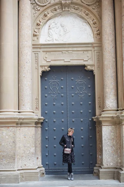 Young wonan poses in front of the Santa Maria de Montserrat Abbey, Catalonia, Spain. — Stock Photo, Image