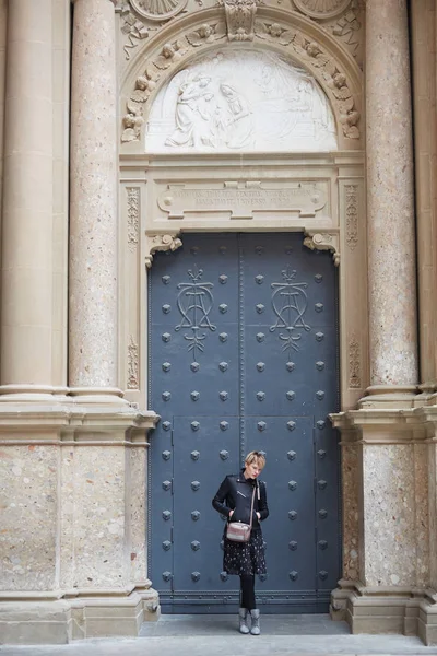 Young wonan poses in front of the Santa Maria de Montserrat Abbey, Catalonia, Spain. — Stock Photo, Image