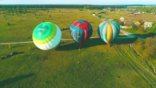 Felszállás a hőlégballon, a naplemente, hőlégballonok start menet közben füves területen a nyári naplemente, air lufi mező az emberek nyári estén, egy léggömb repülés előkészítése — Stock videók