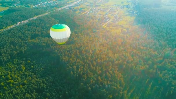 Vliegen over de heteluchtballon. Heteluchtballon in de lucht over een veld op het platteland. Luchtfoto. Hete lucht ballon in de lucht over een veld op het platteland. — Stockvideo