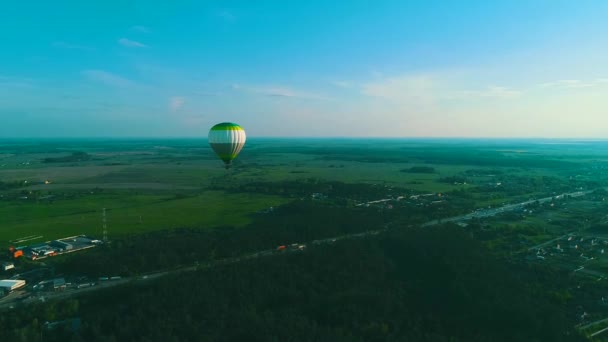 熱気球の上を飛ぶ。田舎の野原の上空に熱気球。航空写真。田舎の野原の上空の熱気球. — ストック動画