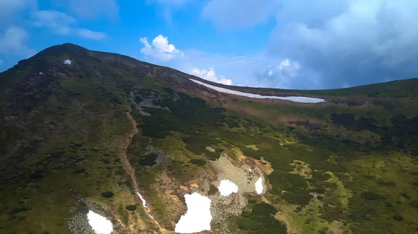 Mountain ridge with rocky outcrops. Panoramic view from the top of the ridge on background of valley. Carpathian Mountains