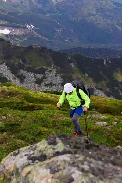 Man traveling with backpack hiking in mountains Travel Lifestyle success concept adventure active vacations outdoor mountaineering sport plaid shirt hipster clothing — Stock Photo, Image