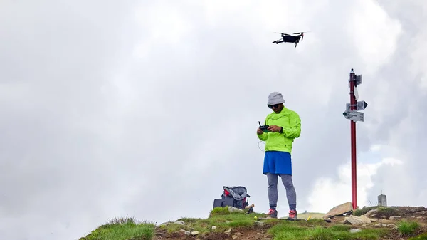 Guy tourist launches quadrocopter in the mountains — Stock Photo, Image