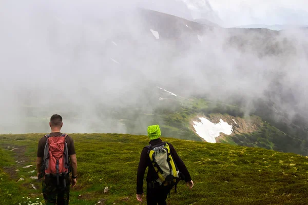 Men silhouettes in fog. Men traveling hiking in mountains.