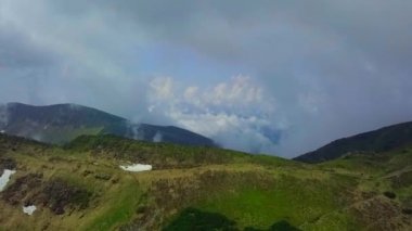 Hava Aracı Manzarası: Çam ağacı ormanı ve şehir yolu üzerinde günbatımının yumuşak ışığında uçmak. Arka planda sıradağlar var. Doğa, seyahat, tatiller. Karpatlar, Ukrayna, Avrupa