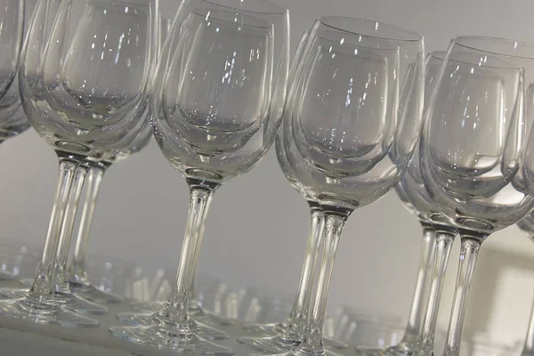 Welcome drink. Rows of empty wine or champagne glasses close up. glass goblets on the white table. Empty crystal wineglass. glass goblet on a high leg. Restaraunt bar concept. — Stock Photo, Image