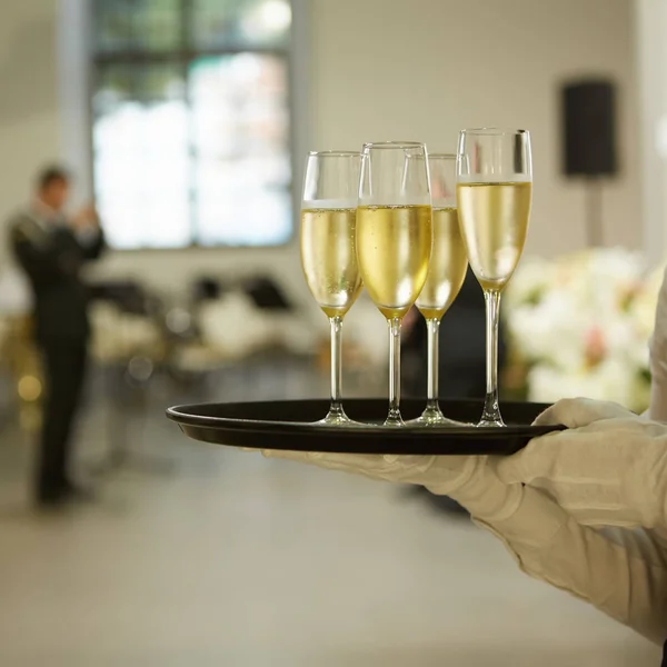 Un vassoio con tre bicchieri di champagne. Cameriere che tiene un vassoio con un bicchiere di champagne — Foto Stock