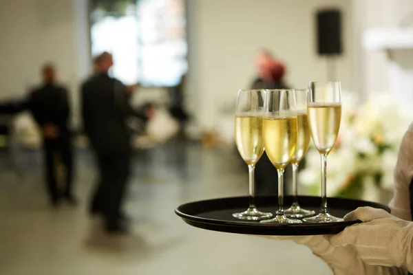 En bricka med tre glas champagne. Servitör håller en bricka med ett champagneglas — Stockfoto