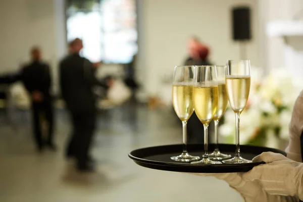 Un vassoio con tre bicchieri di champagne. Cameriere che tiene un vassoio con un bicchiere di champagne — Foto Stock