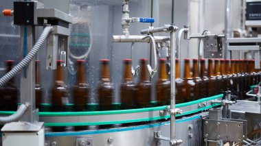 Bira şişeleri hareket bulanıklığı. Konveyör bandında bira şişeleri. Sığ DOF. Seçici odak.