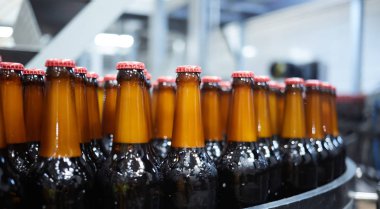 Konveyör bandında bira şişeleri. Sığ DOF. Seçici odak.