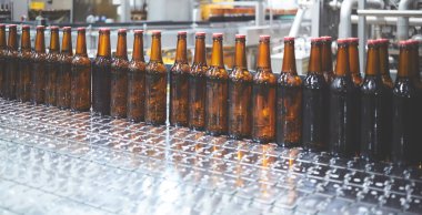 Konveyör bandında bira şişeleri. Sığ DOF. Seçici odak.