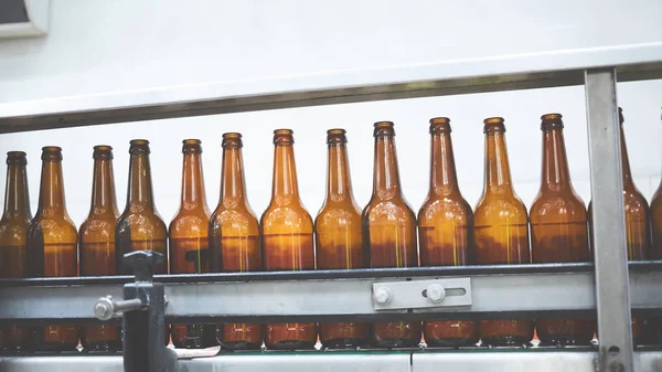 Beer bottles on the conveyor belt. Shallow dof. Selective focus. — Stock Photo, Image