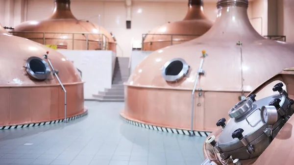 Equipamento de preparação de cerveja. Linhas de tanques de cobre na cervejaria. Processo de fabricação de brewage. Modo de produção de cerveja. Vista interior da cervejaria moderna com barris . — Fotografia de Stock