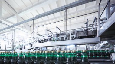 Bira veya gazlı içecek için plastik şişeler konveyör üzerinde hareket ediyor. Sığ Dof. Seçici odaklama.