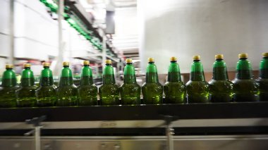Bira veya gazlı içecek için plastik şişeler konveyör üzerinde hareket ediyor. Sığ Dof. Seçici odaklama.